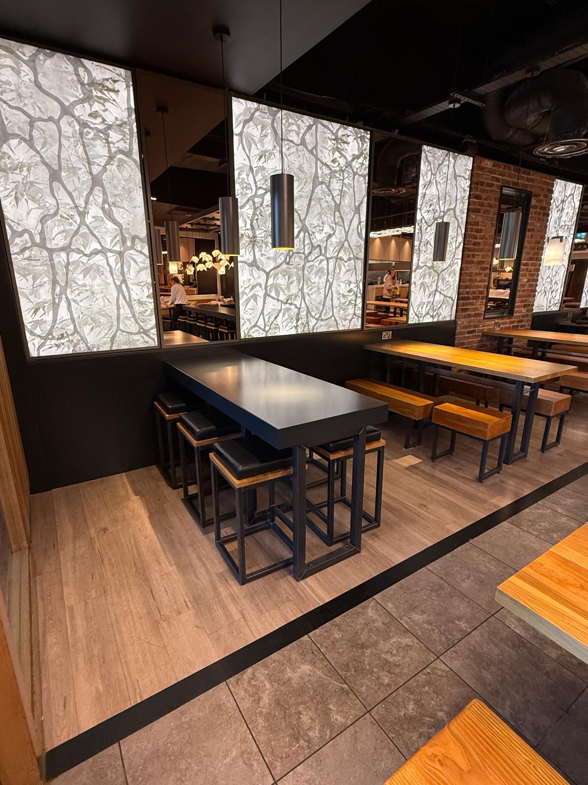 Wooden tables and benches at Wagamama Cheshire Oaks